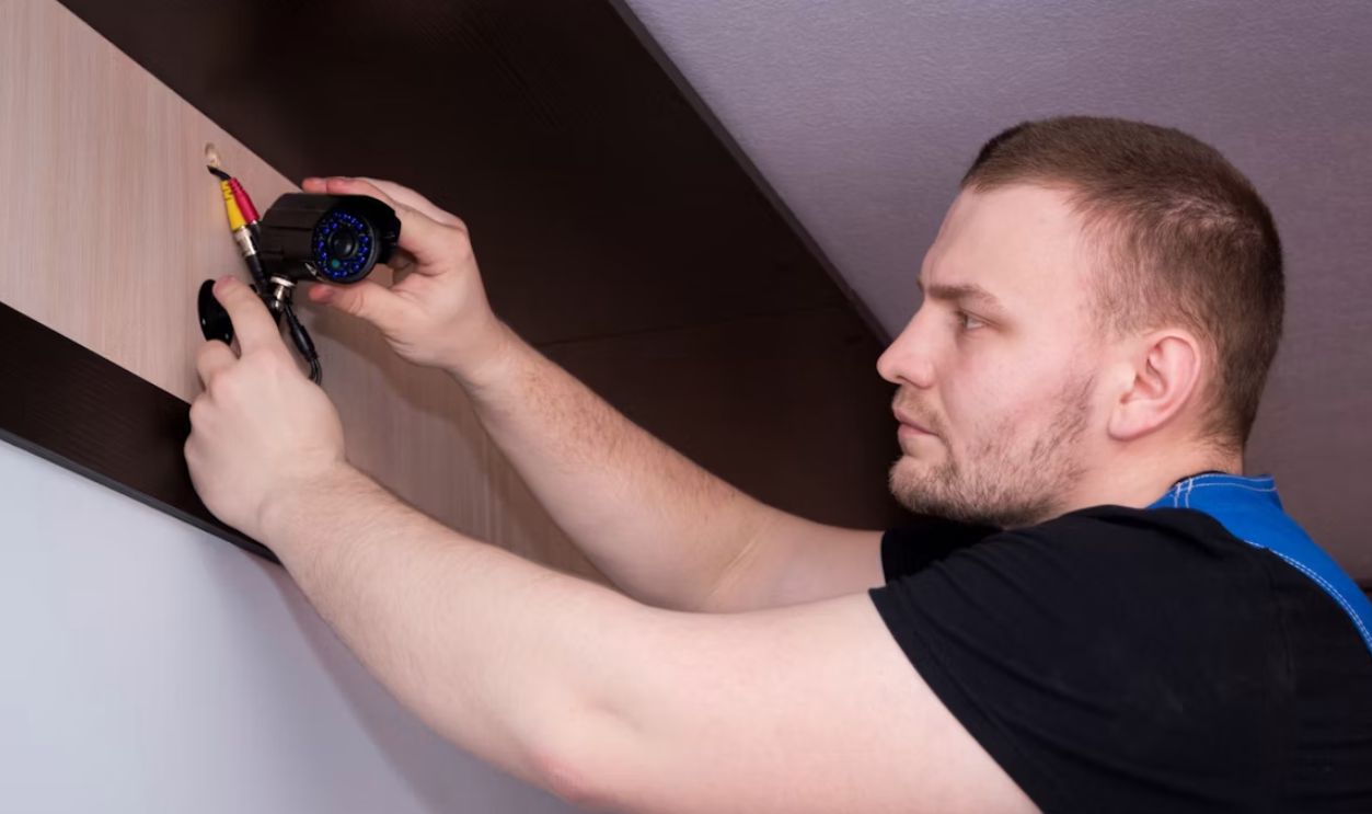 a man working on a wall with a screwdriver