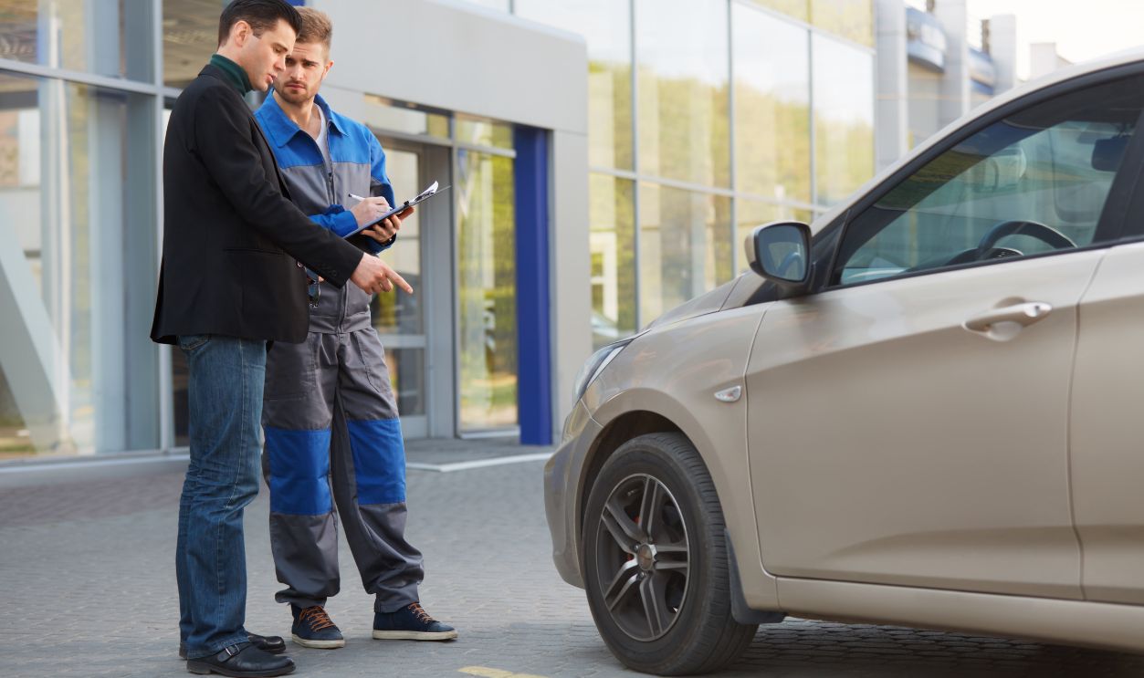 Shutterstock-281555204, Mechanic and Customer Discussing Problem With Car. Auto Repair Shop
