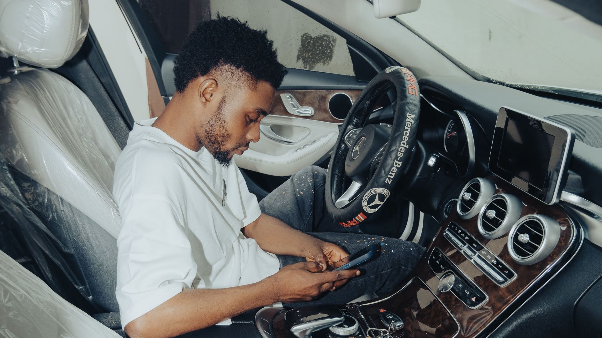 A man in a luxury car's interior, showcasing a modern lifestyle and relaxation.