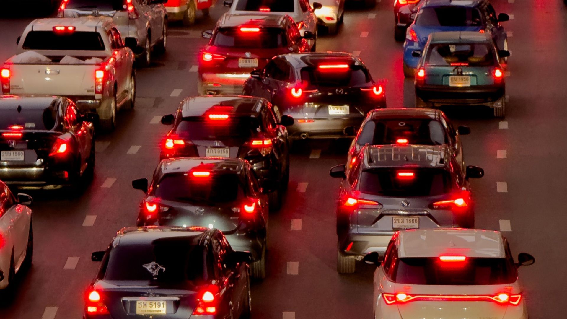 Heavy traffic jam in downtown Bangkok at twilight with numerous cars