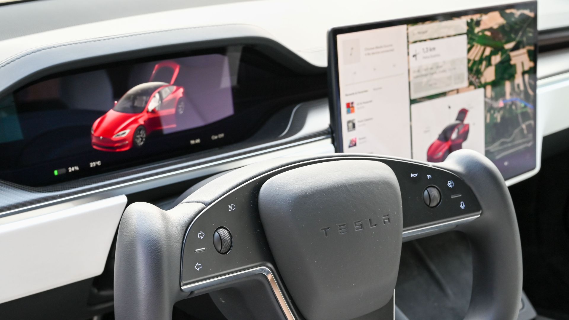 Premium Tesla dashboard featuring dual screens and innovative steering wheel design.