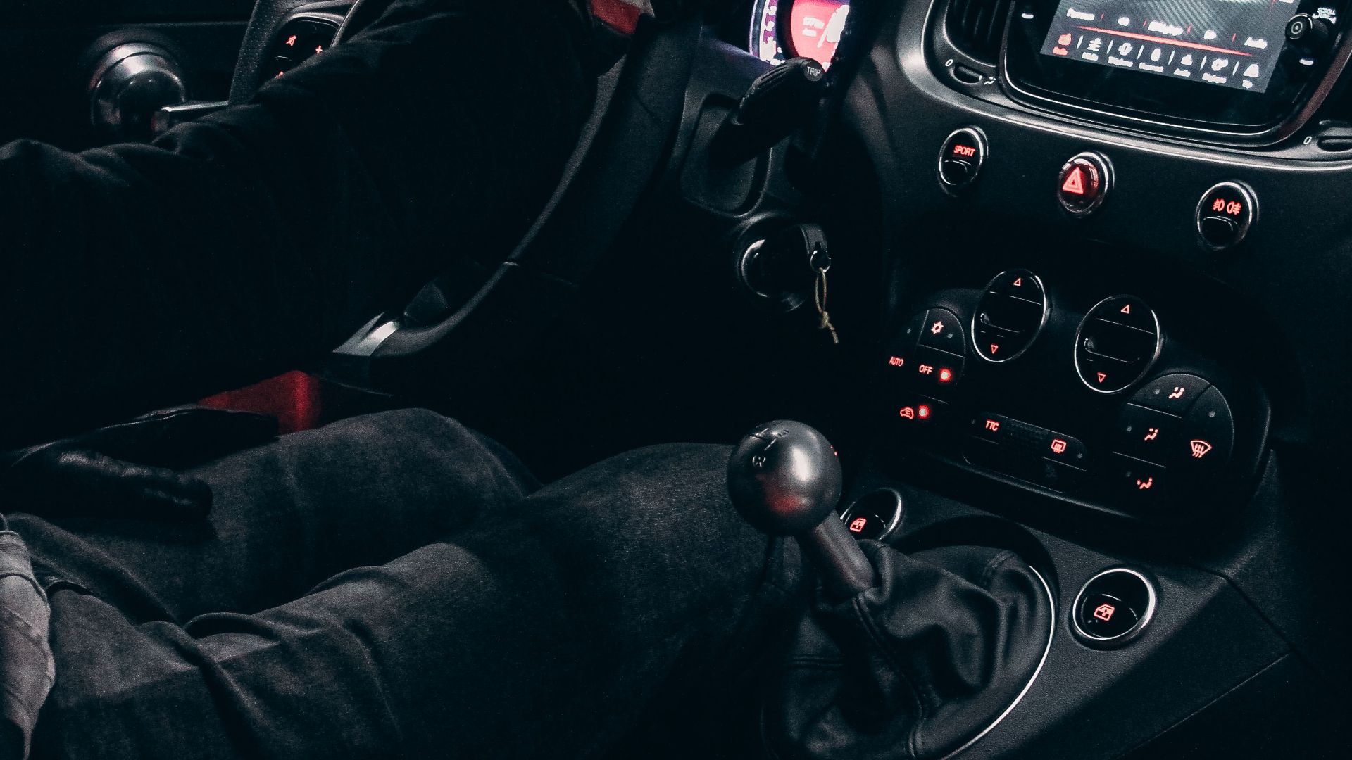 View of a driver handling a car interior with modern features in a Rabat garage.