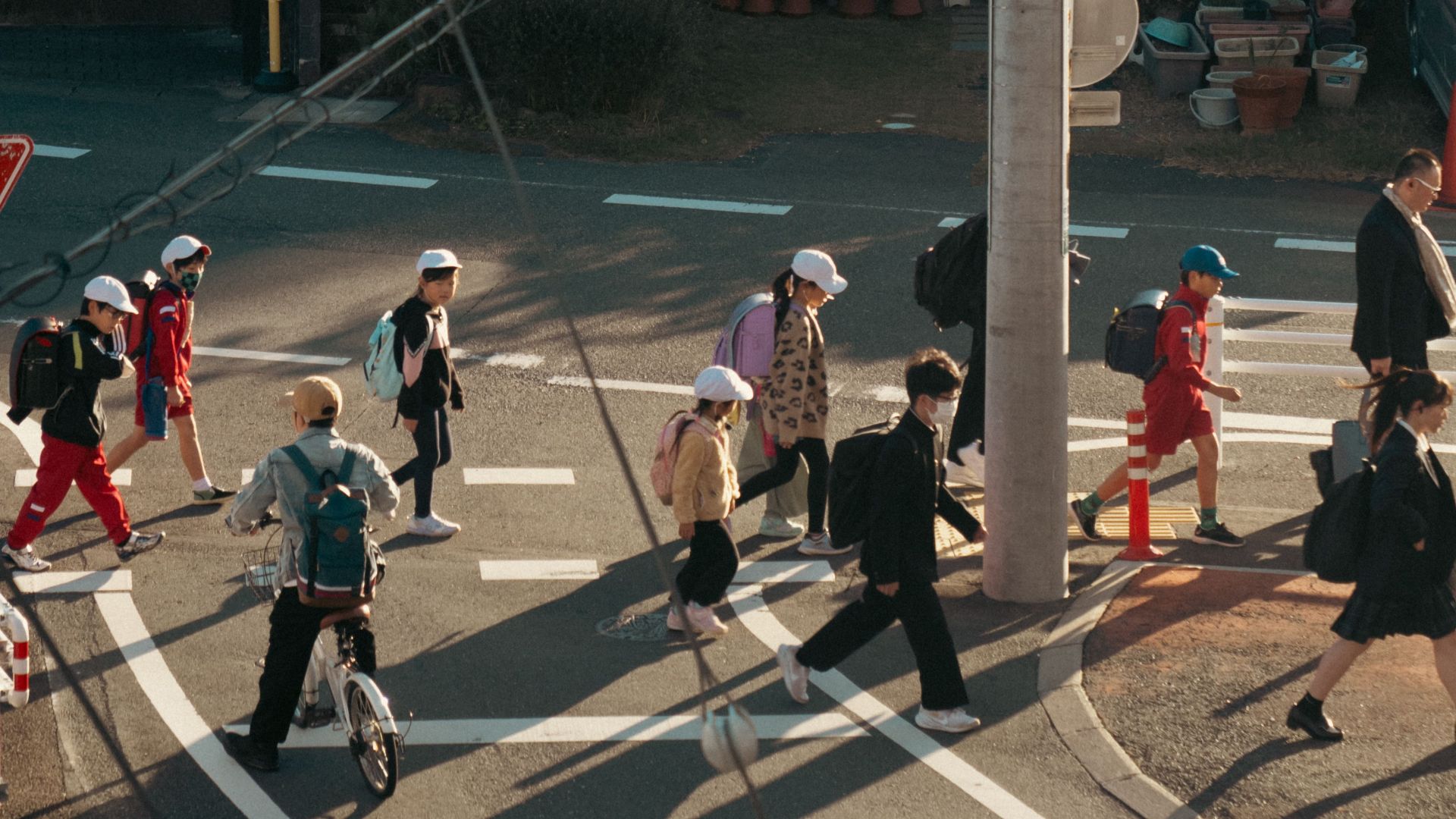 Aerial view of pedestrians, including school children, crossing a street in Toyokawa, Japan.