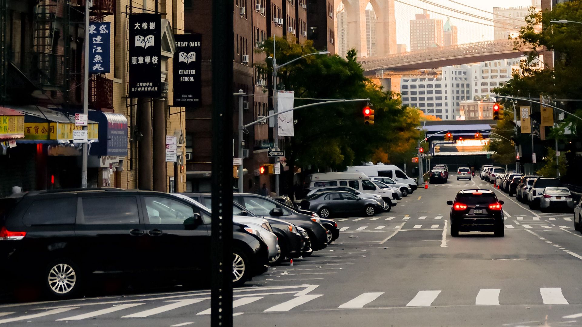 Street view in NYC featuring Brooklyn Bridge, traffic light, and urban architecture.
