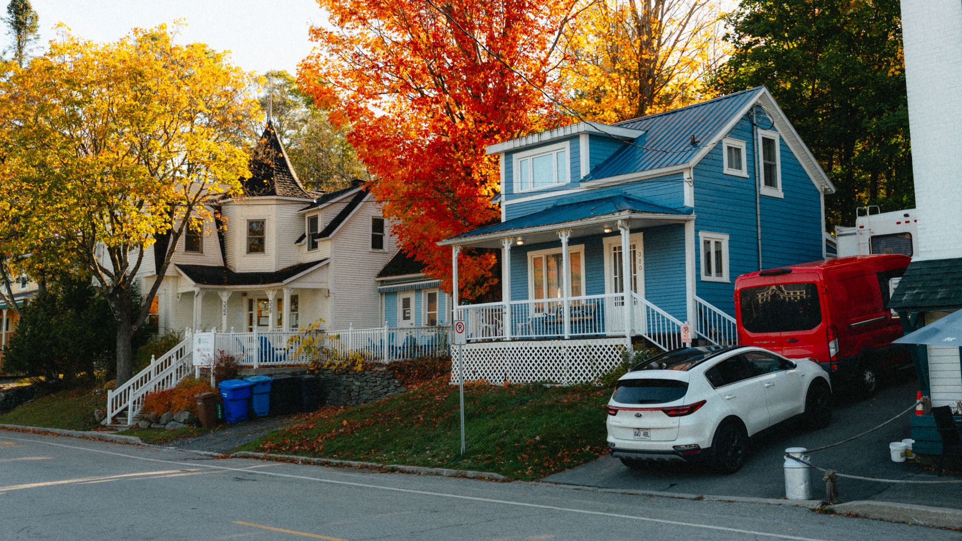 Colorful houses surrounded by vibrant autumn foliage in North Hatley, Québec, Canada.