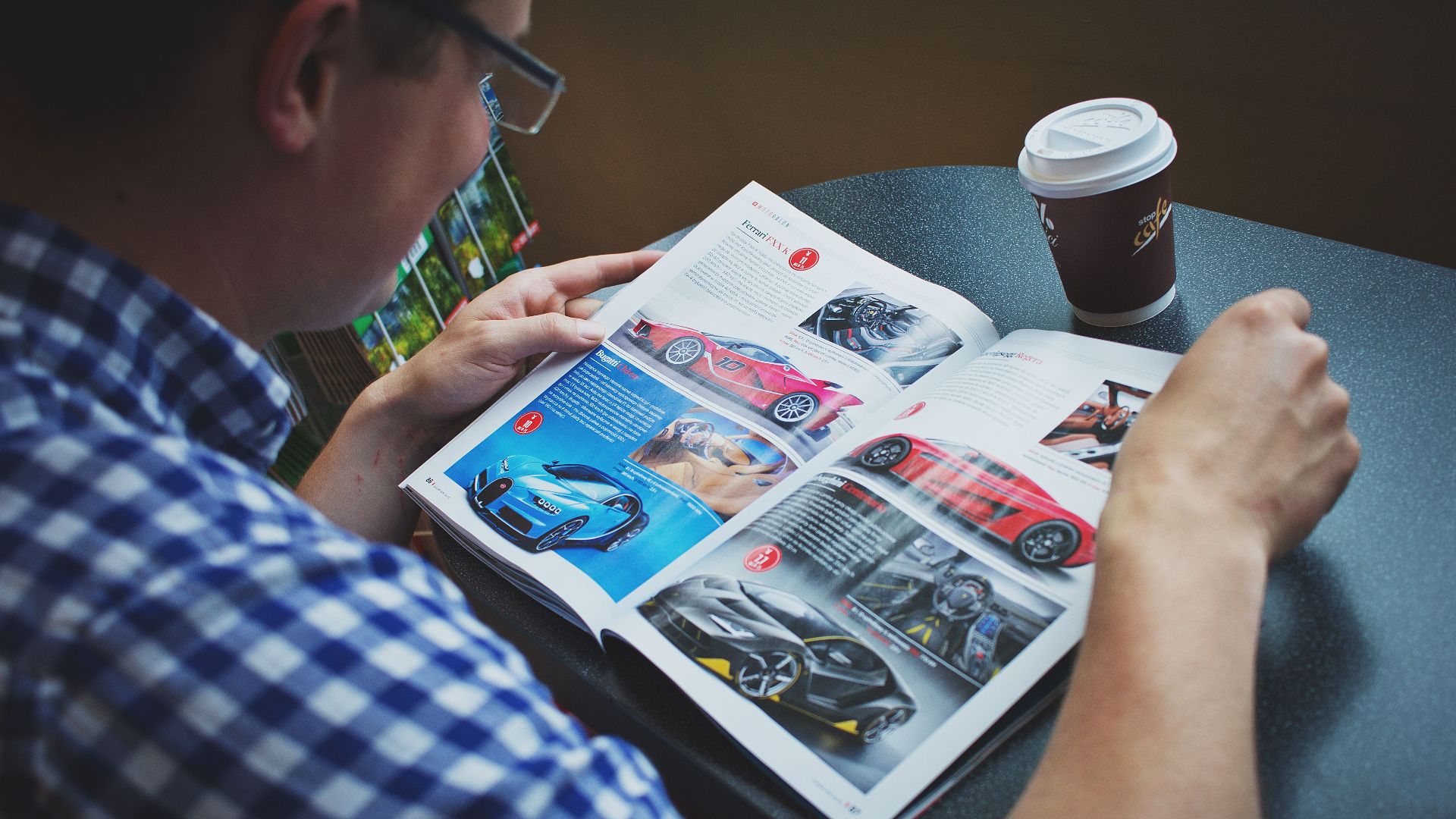 Adult man enjoying coffee while reading a car magazine. Perfect lifestyle image.