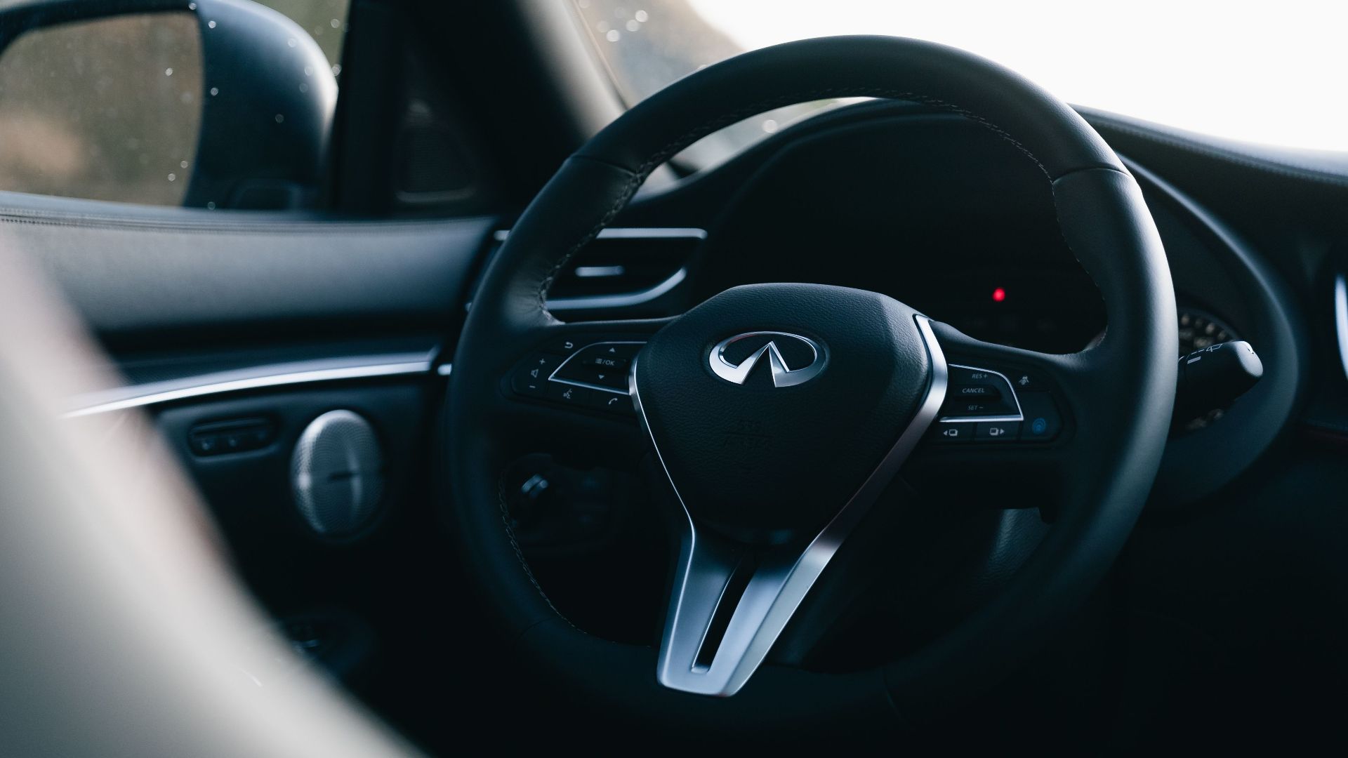 Close-up shot of a luxury car steering wheel showcasing sleek design and elegance.