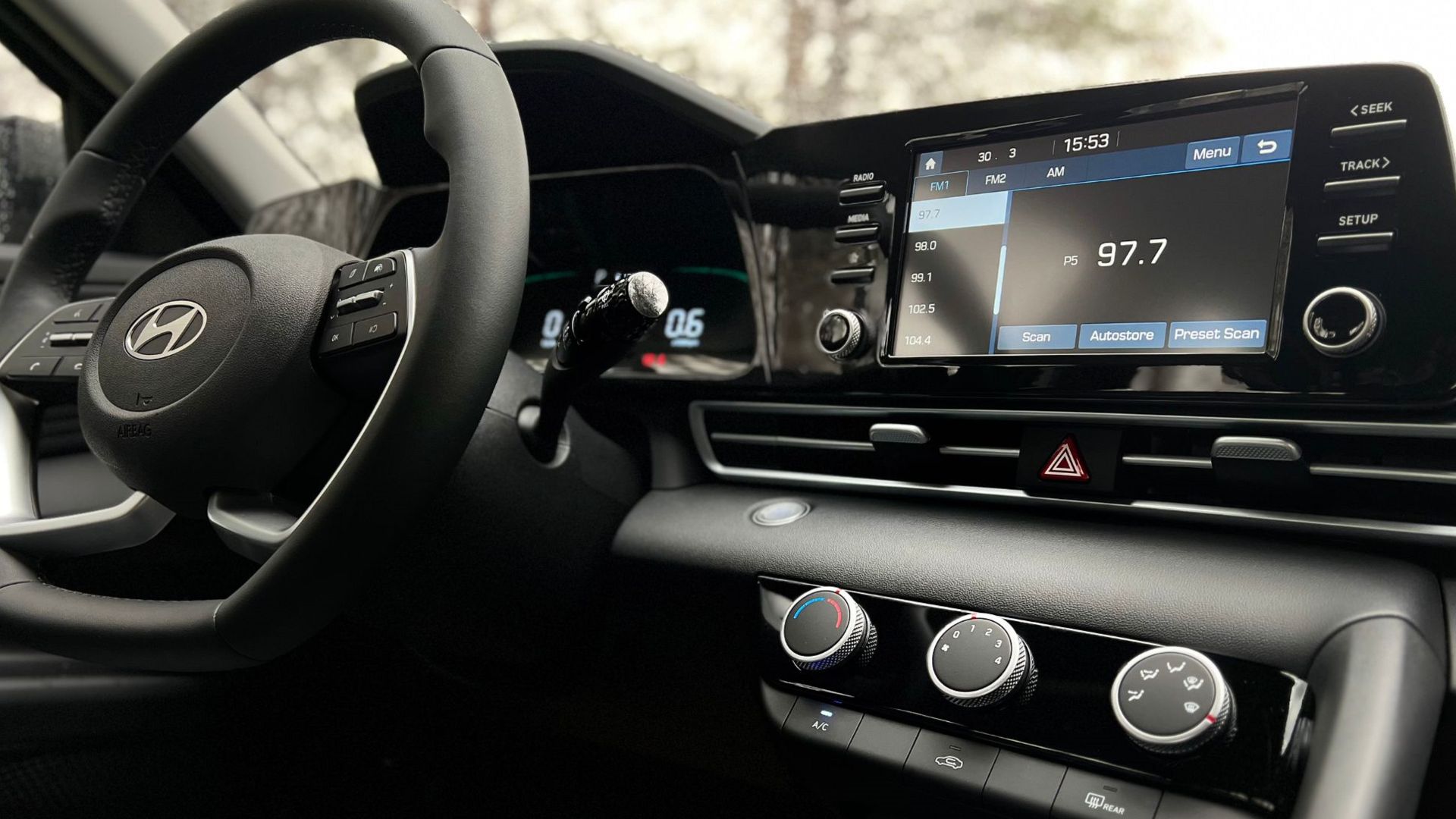 Interior view of a modern car dashboard featuring a touchscreen infotainment system and steering wheel.