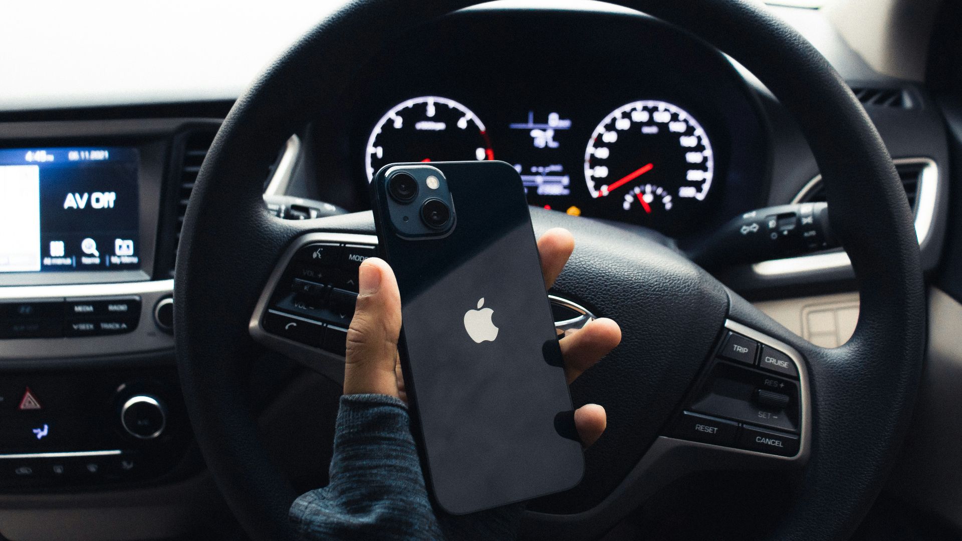 a person holding a cell phone in a car