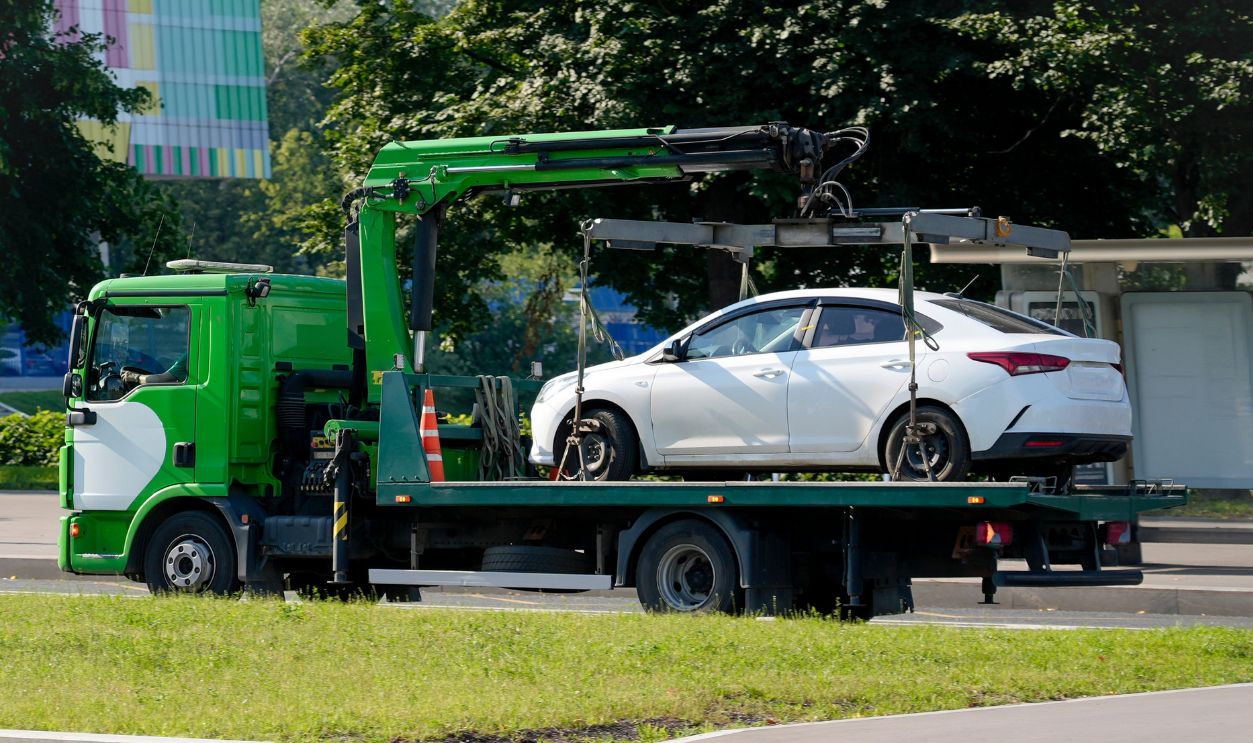 Service the tow truck with the loaded car which stopped working. Towing a car to a penalty parking lot for traffic violations - No parking.