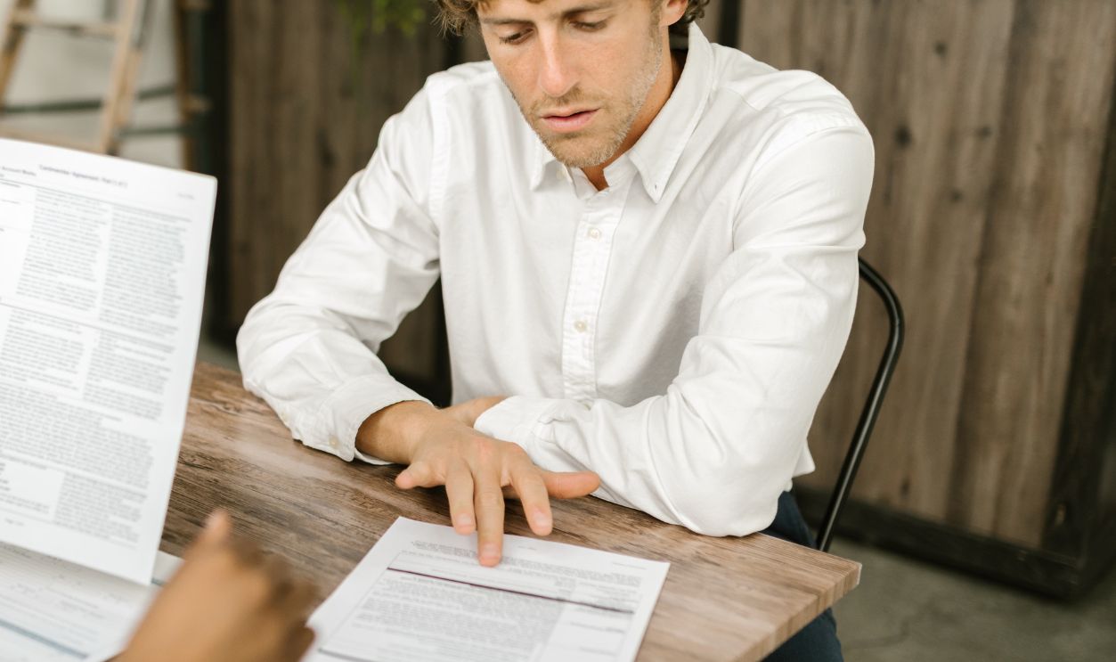 Two professionals reviewing documents in an office setting, focused on analytical tasks.