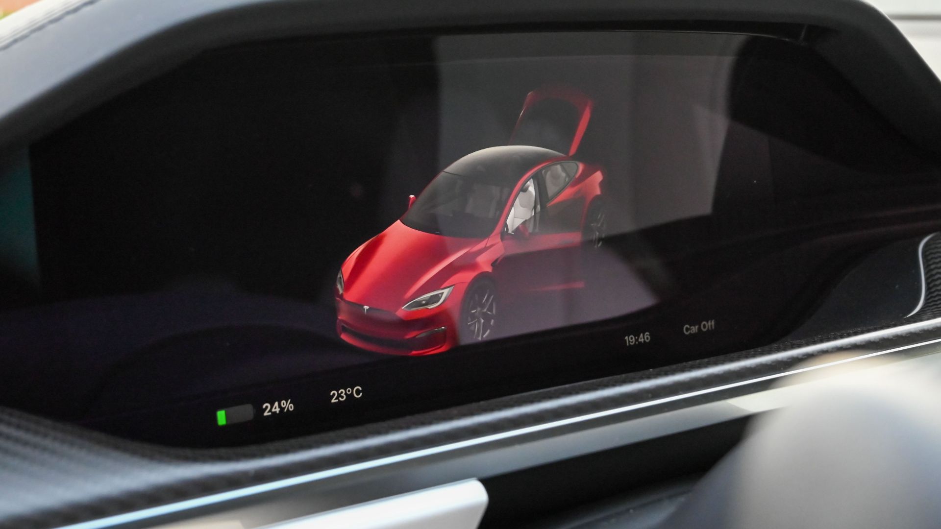 Close-up of a Tesla's dashboard showing the car's status on a digital screen.