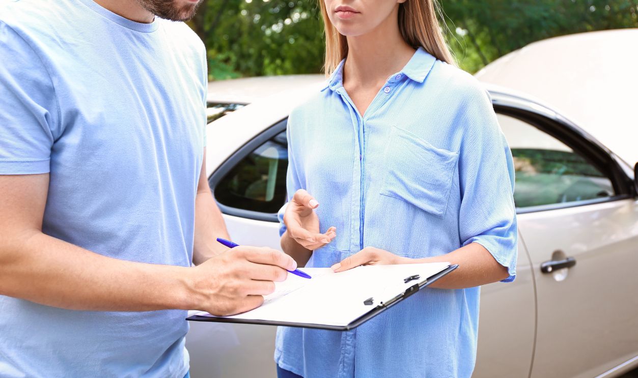Driver and insurance agent near damaged car outdoors