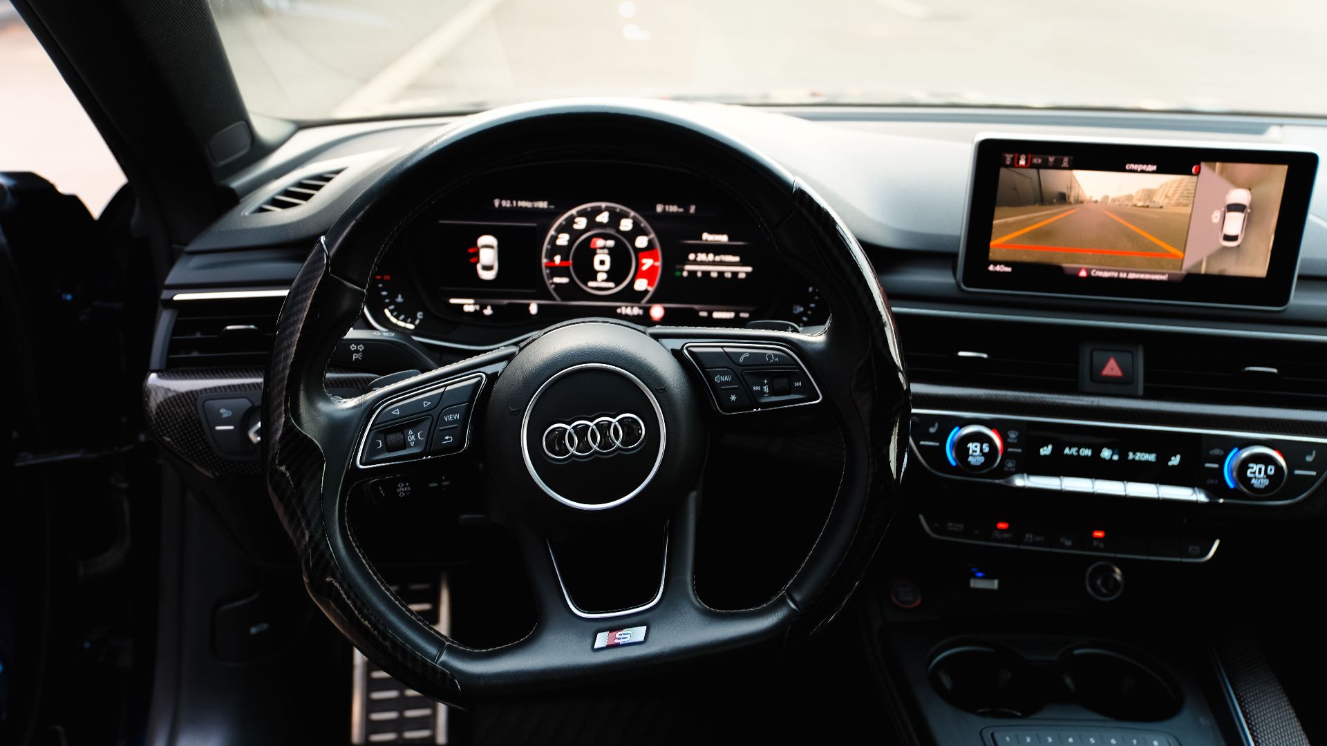 High-tech car interior showcasing a sleek steering wheel and digital dashboard for modern driving.