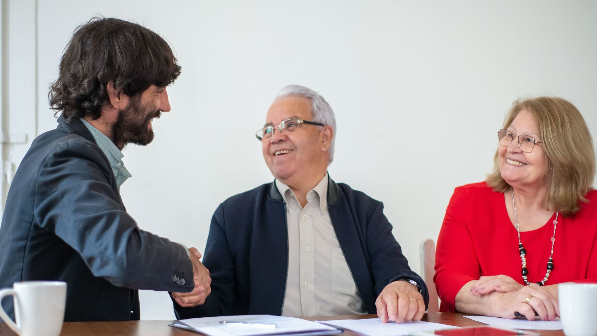 Elderly professionals having a joyful business meeting, shaking hands and smiling