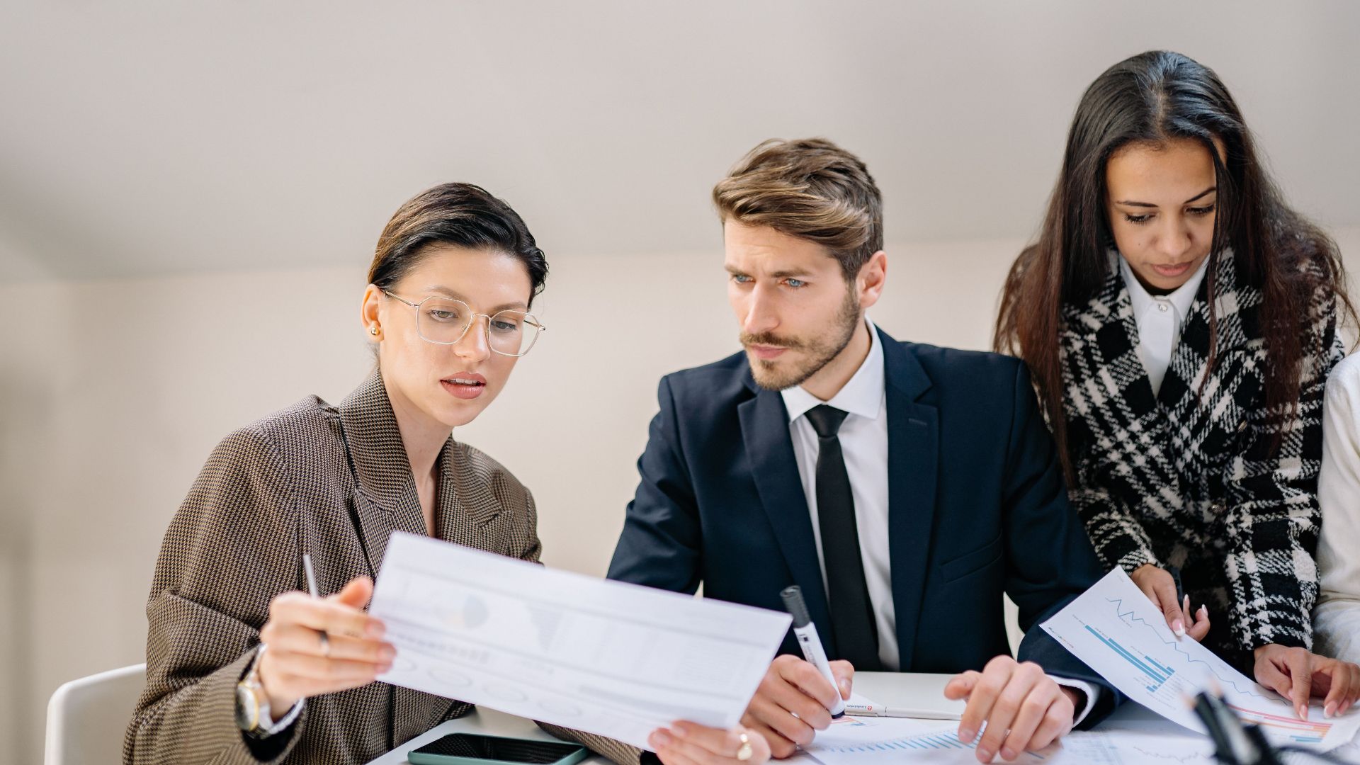 A group of employees reviewing documents in a modern office setting, fostering teamwork and collaboration.