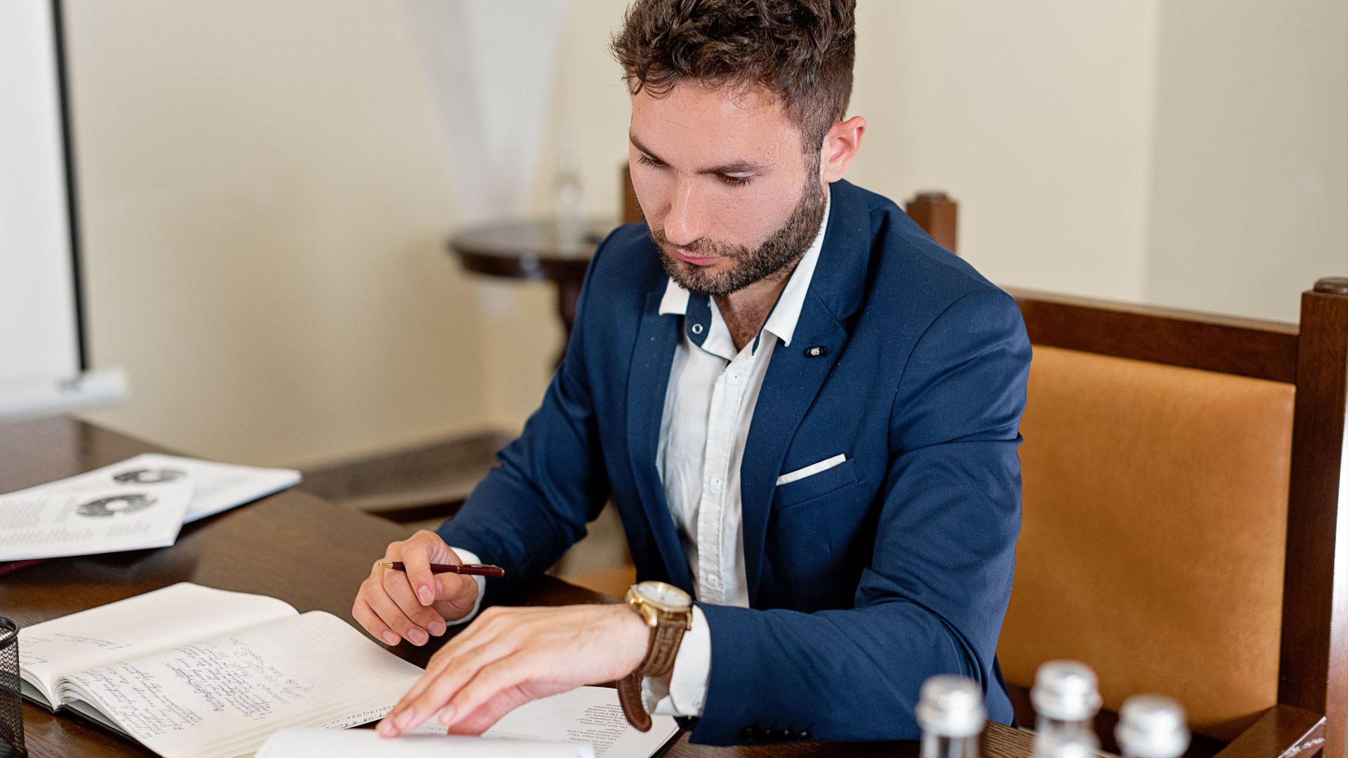 Confident businessman working on documents at a desk in an office setting.