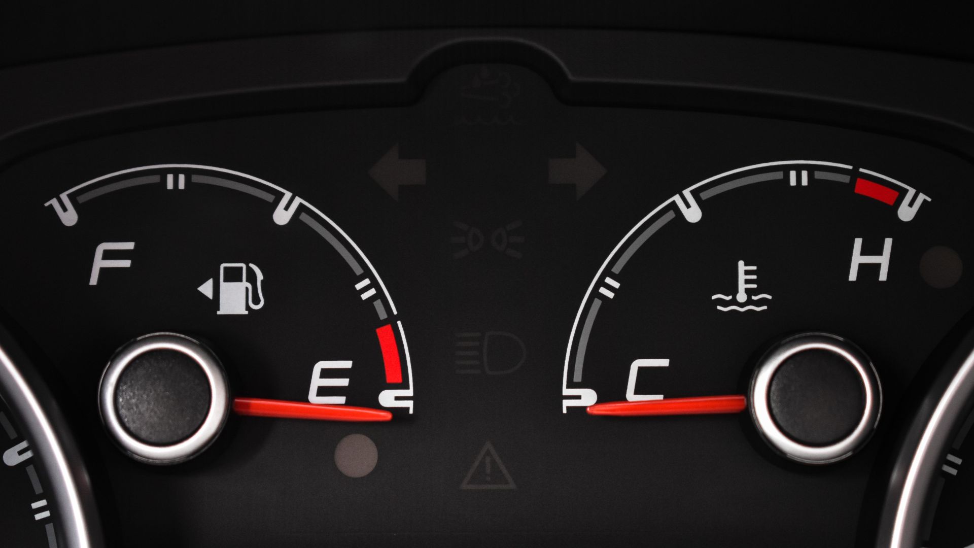 Detailed view of a car's fuel and temperature gauges on dashboard.