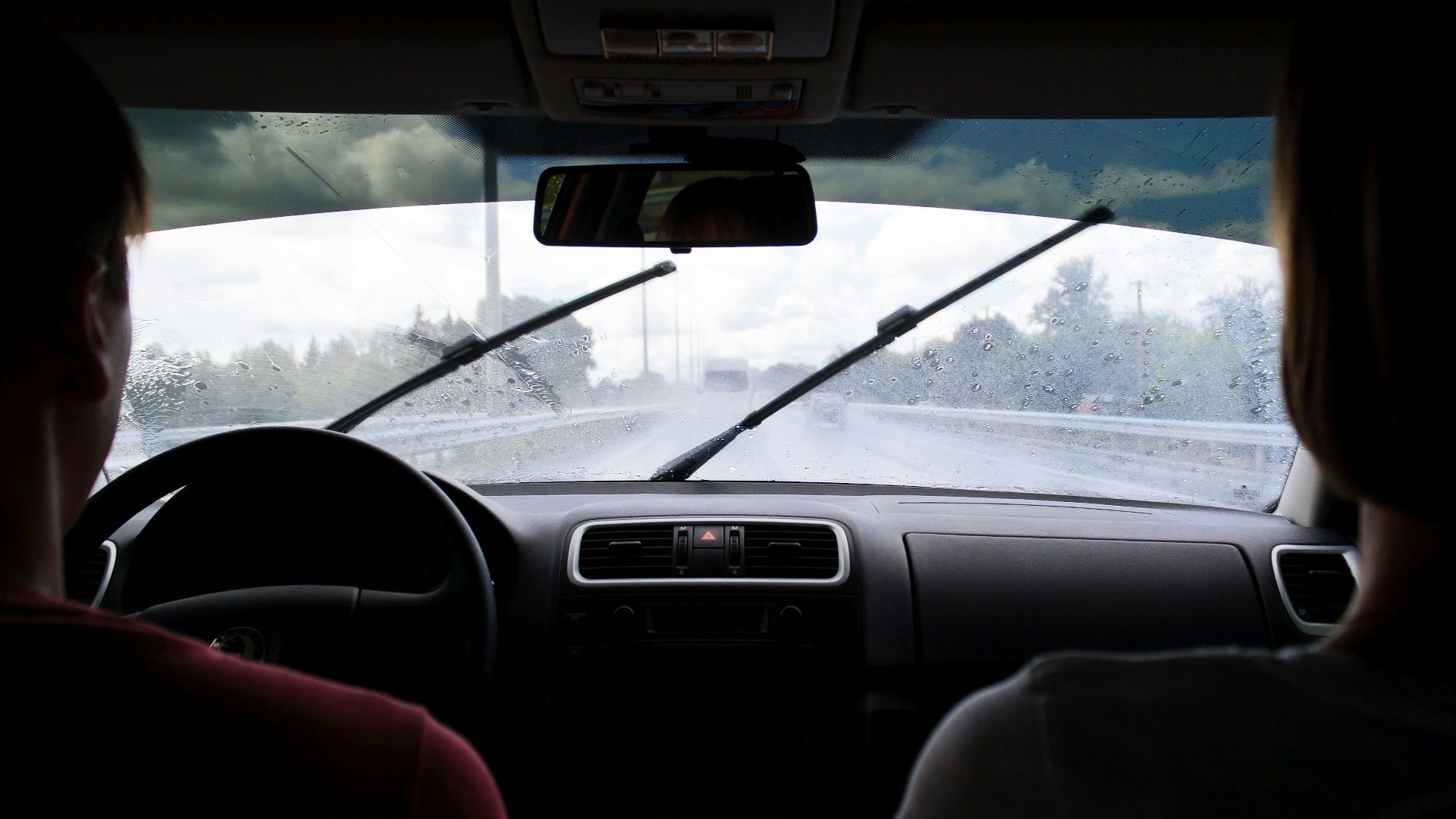two people in car on wet road in rainy day