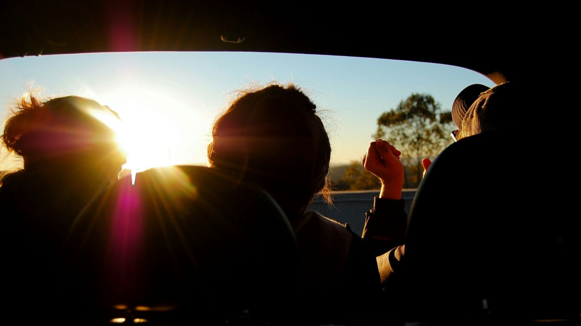 silhouette of three person inside car