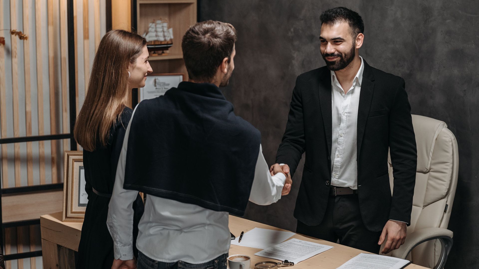 Professional business meeting in modern office setting with a handshake.