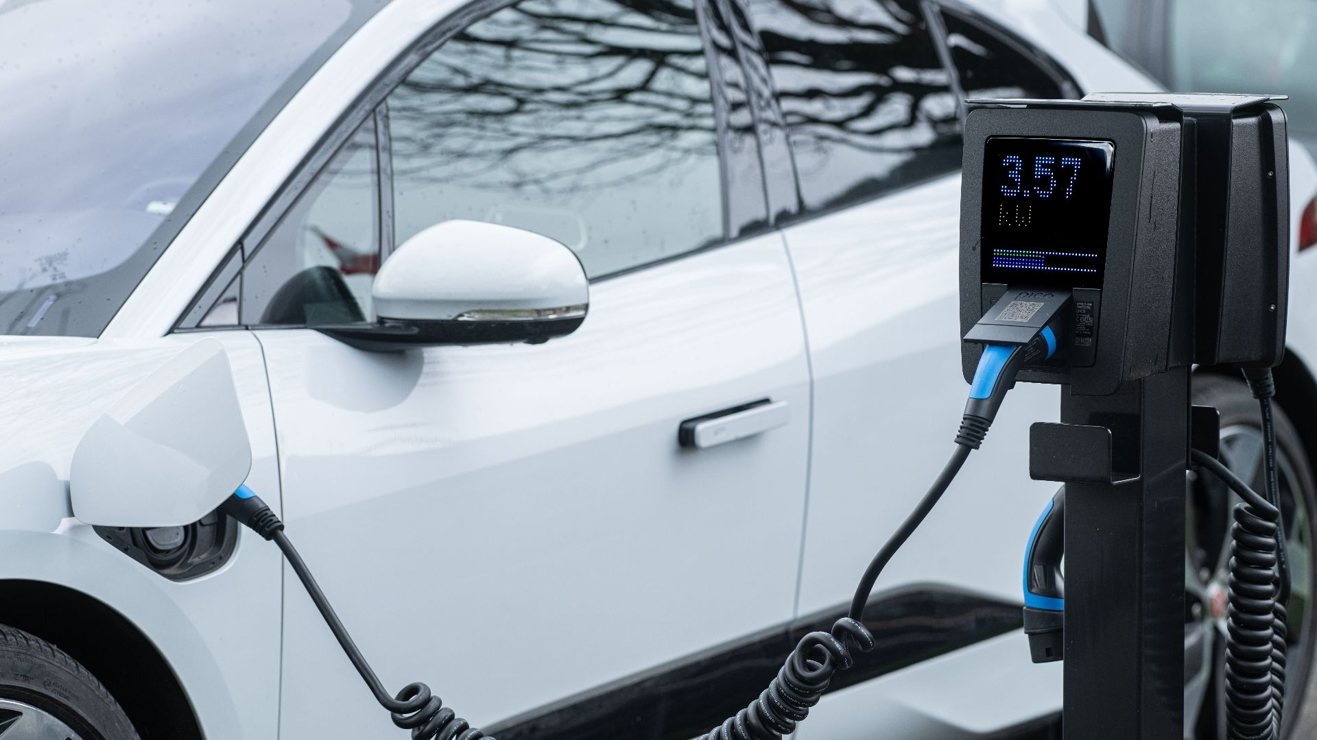 Close-up of an electric vehicle charging at a station, showcasing energy-efficient technology.