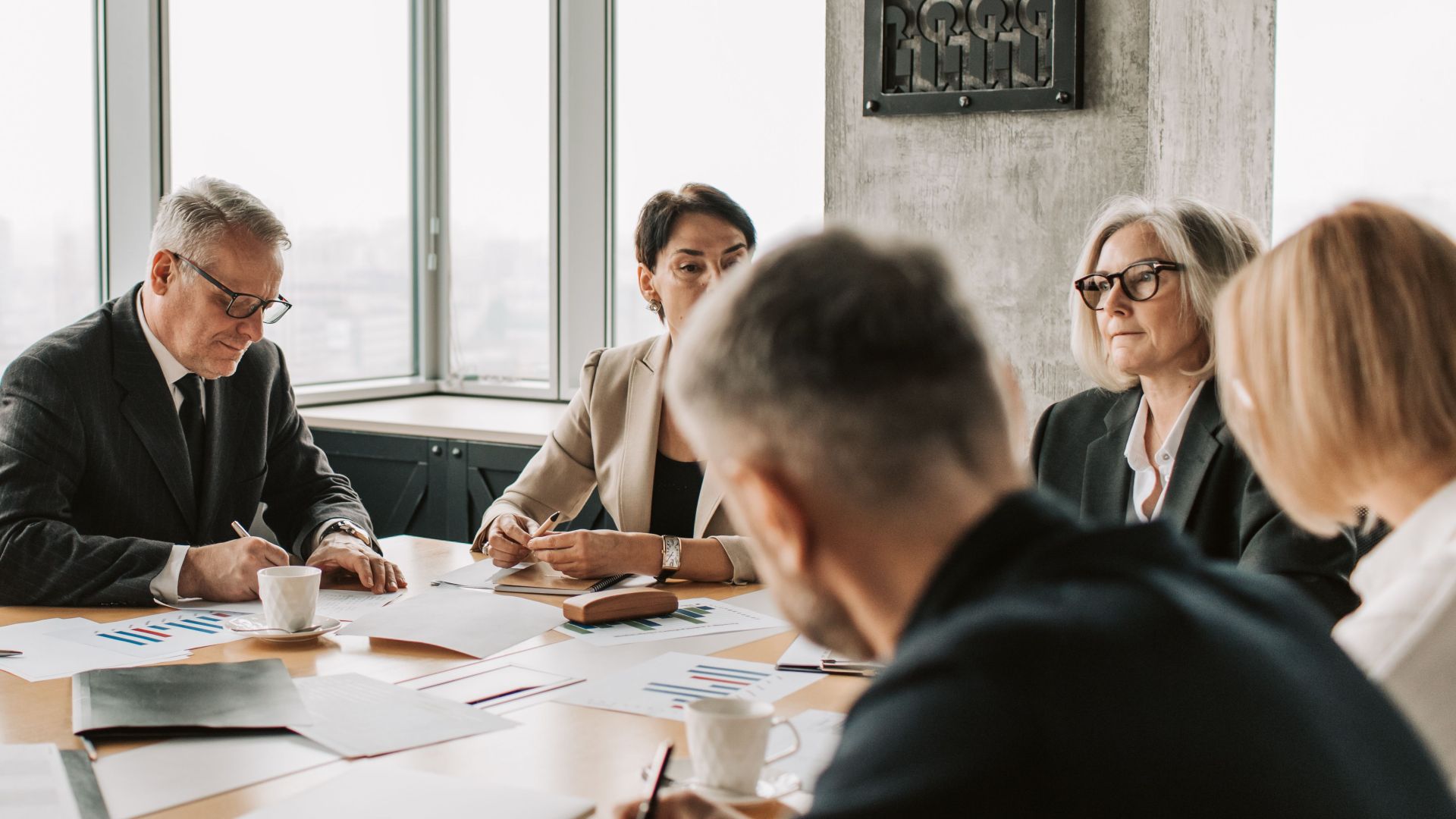 Business professionals engaged in a collaborative meeting around a conference table.