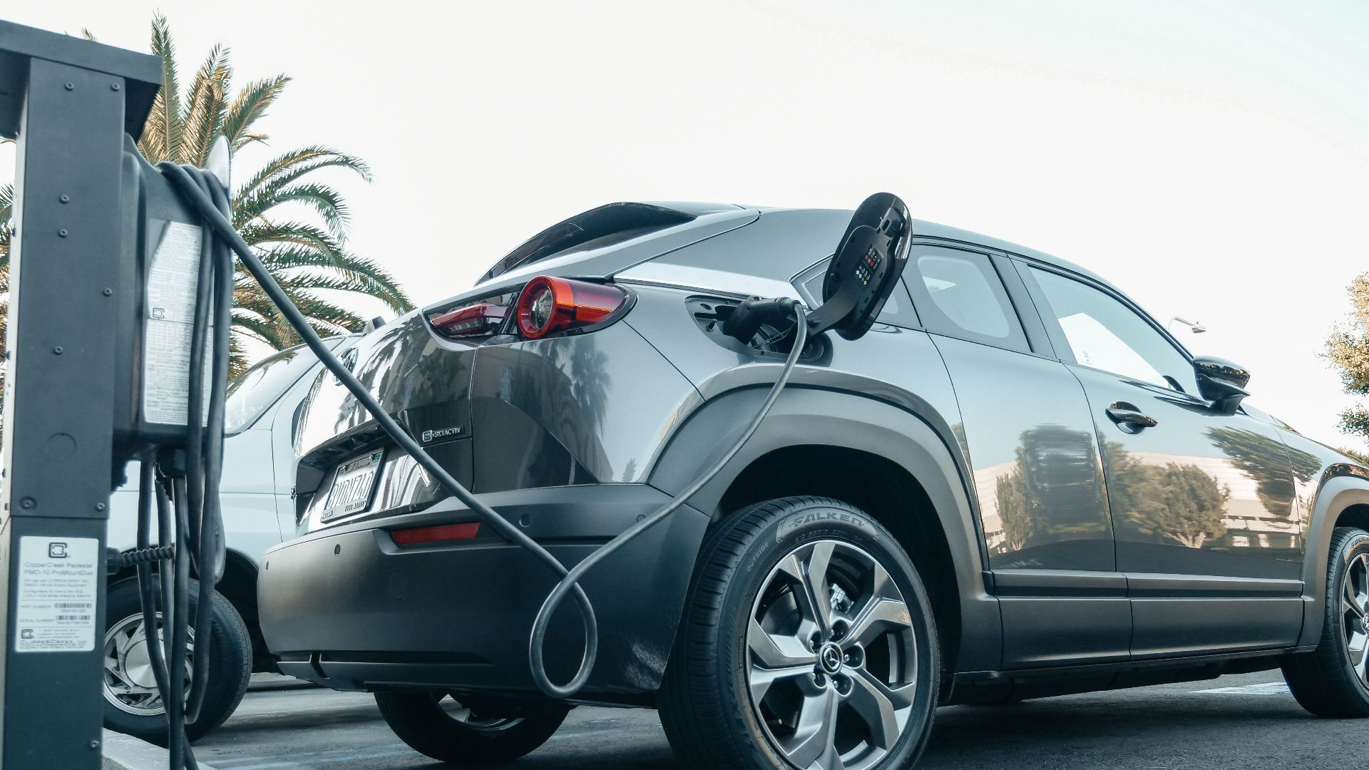 Modern electric vehicle charging at an outdoor station in daylight.