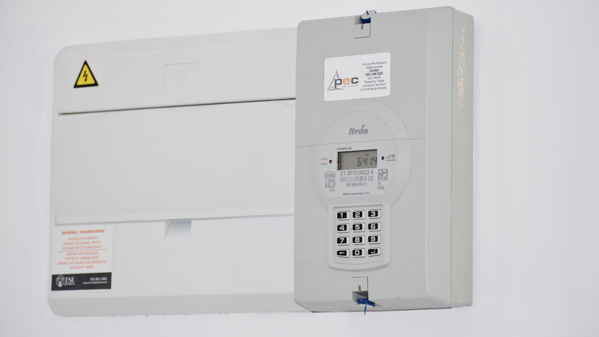 Electrical meter and fuse box on a white wall in Cape Town, South Africa, for energy monitoring or billing.