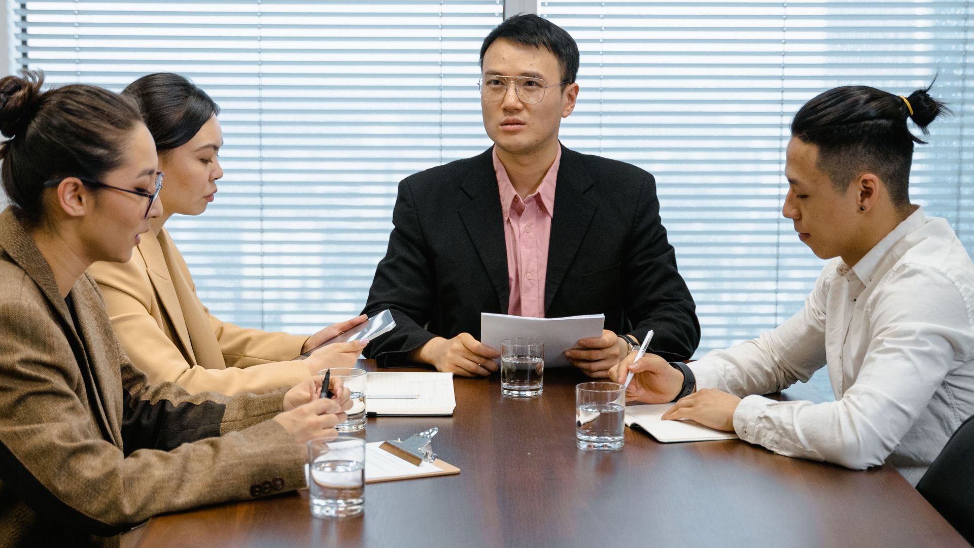 Group of professionals in a boardroom engaged in a focused business meeting.
