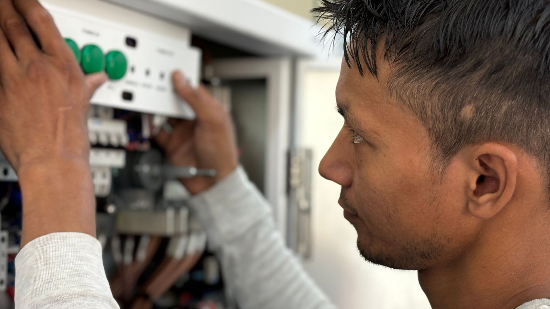 Focused electrician adjusting circuit breaker panel. Technology and skill in action.