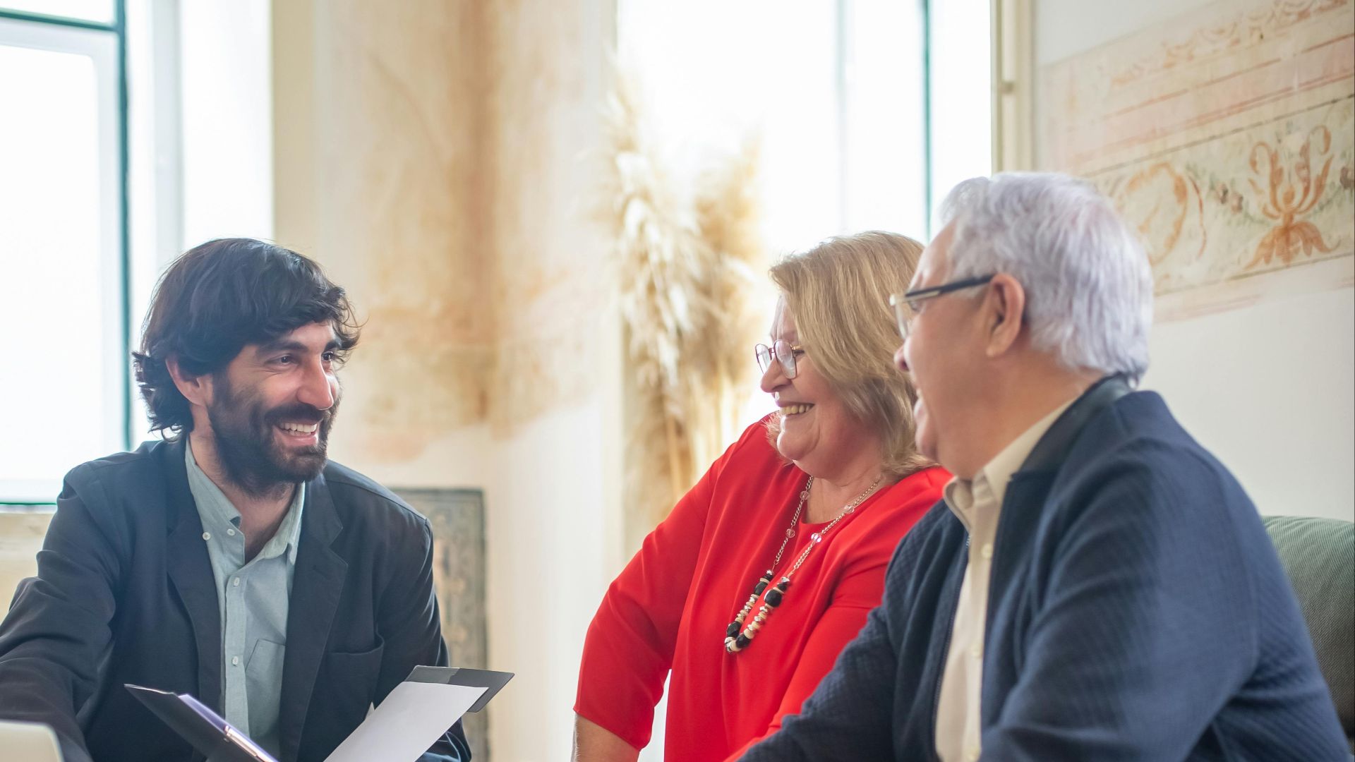 A professional business consultation with a senior couple and advisor indoors.