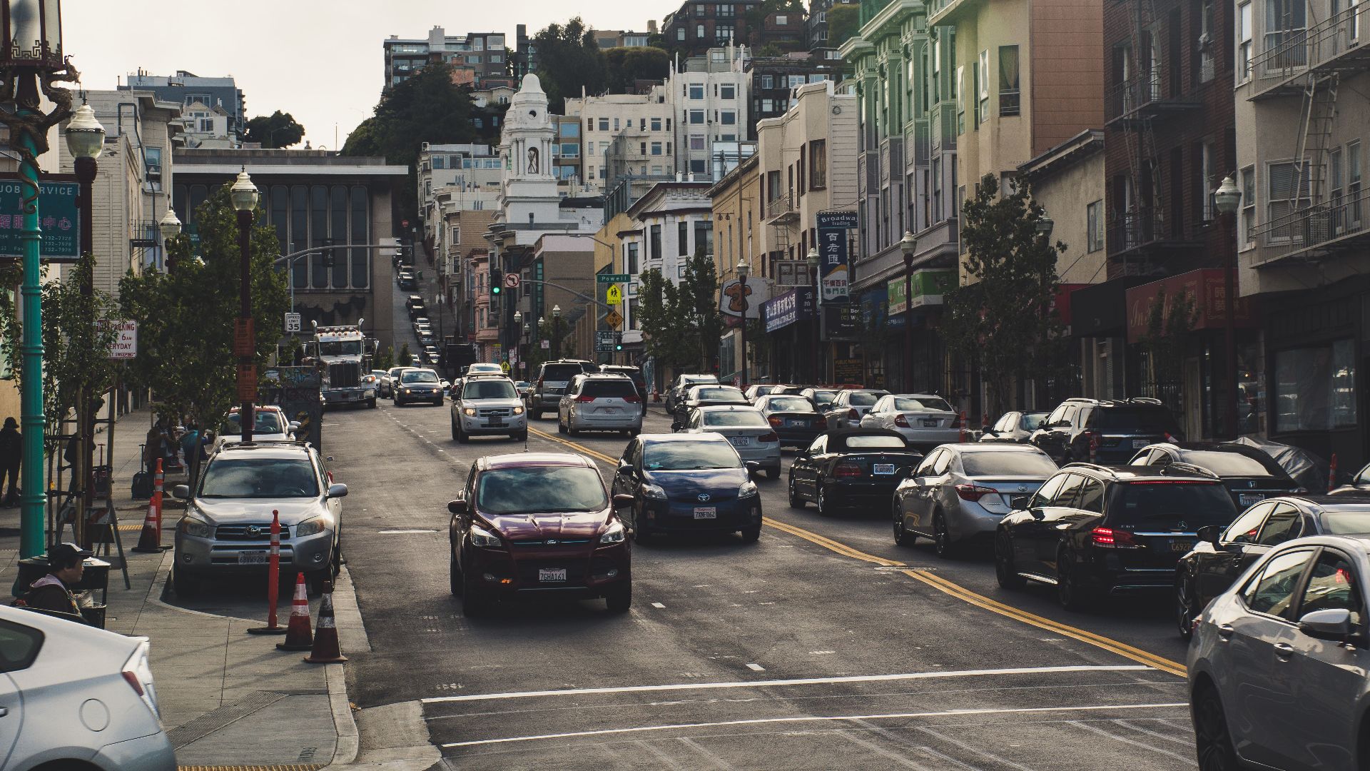 A bustling urban street scene with cars and buildings, depicting vibrant city life.