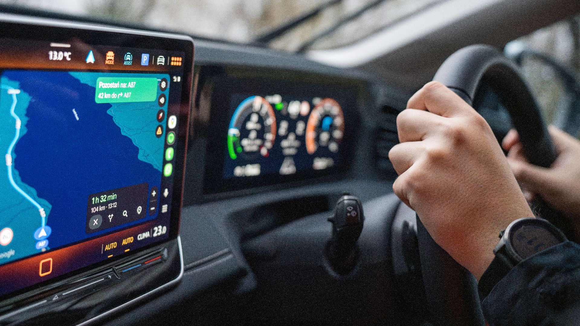 Close-up of hands on steering wheel and GPS navigation on car dashboard, showcasing modern driving technology.