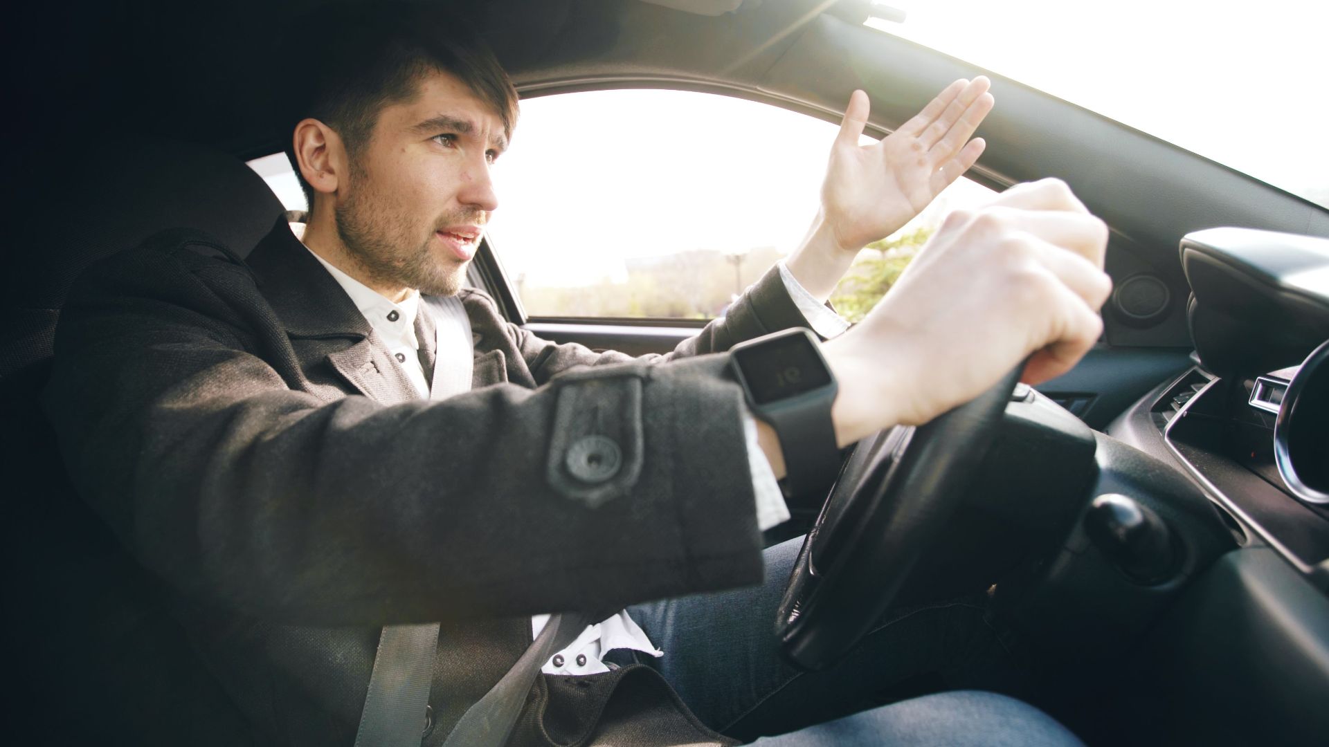 Man showing frustration while driving a car, highlighting road rage issues.