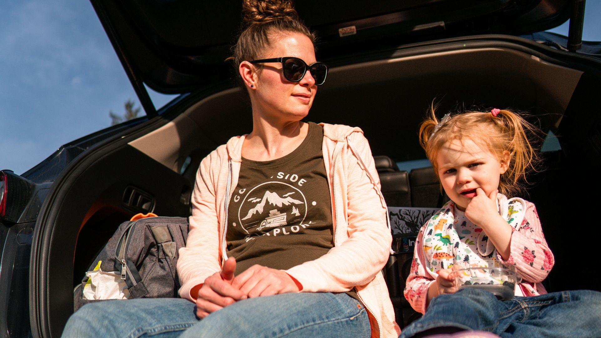 woman in black crew neck t-shirt and blue denim jeans sitting on car seat