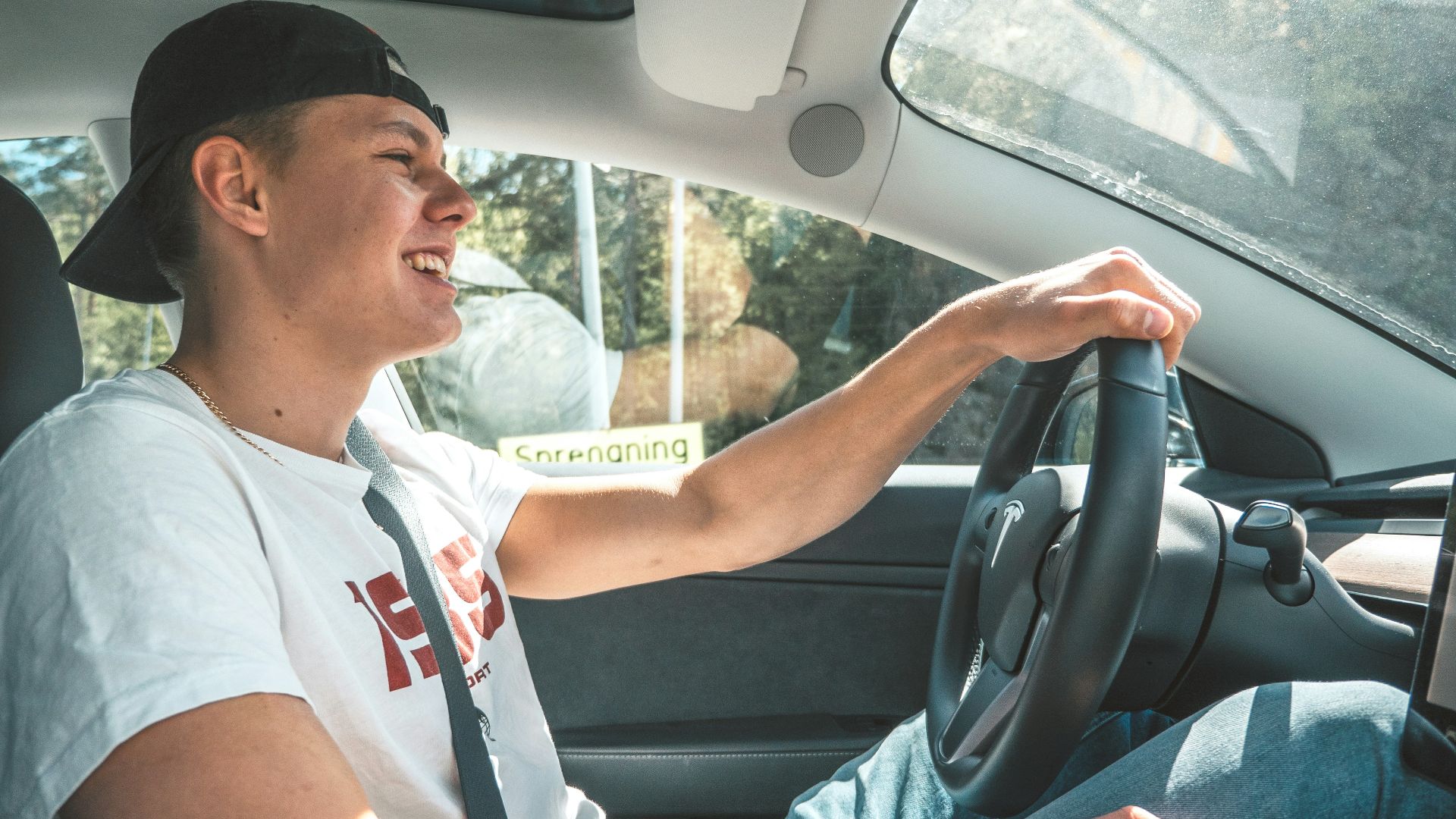 man in white crew neck t-shirt driving car