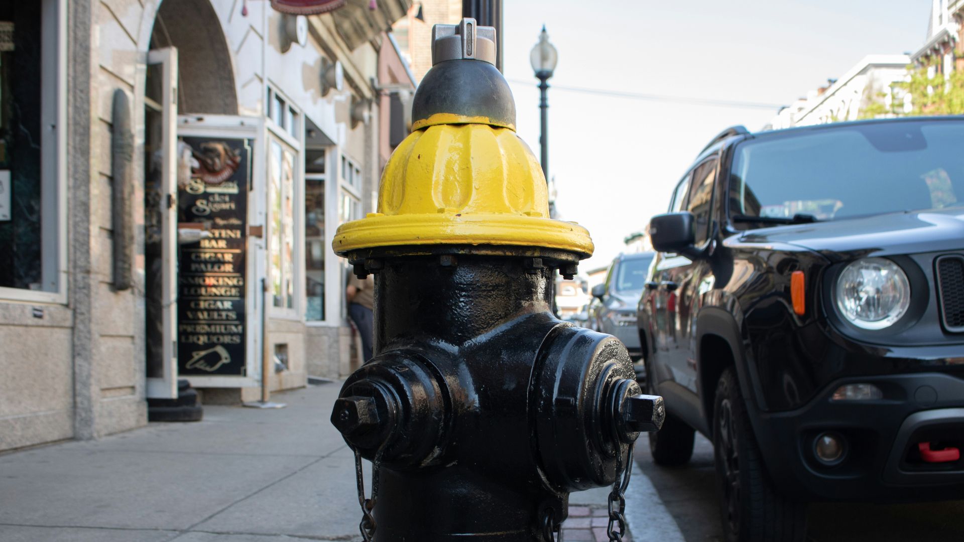 a black and yellow fire hydrant on a city street