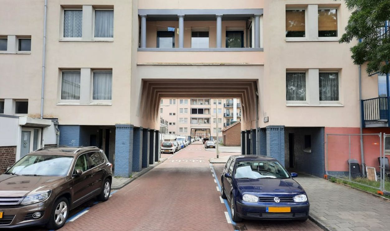 Urban residential area in Amsterdam featuring parked cars and apartment buildings.