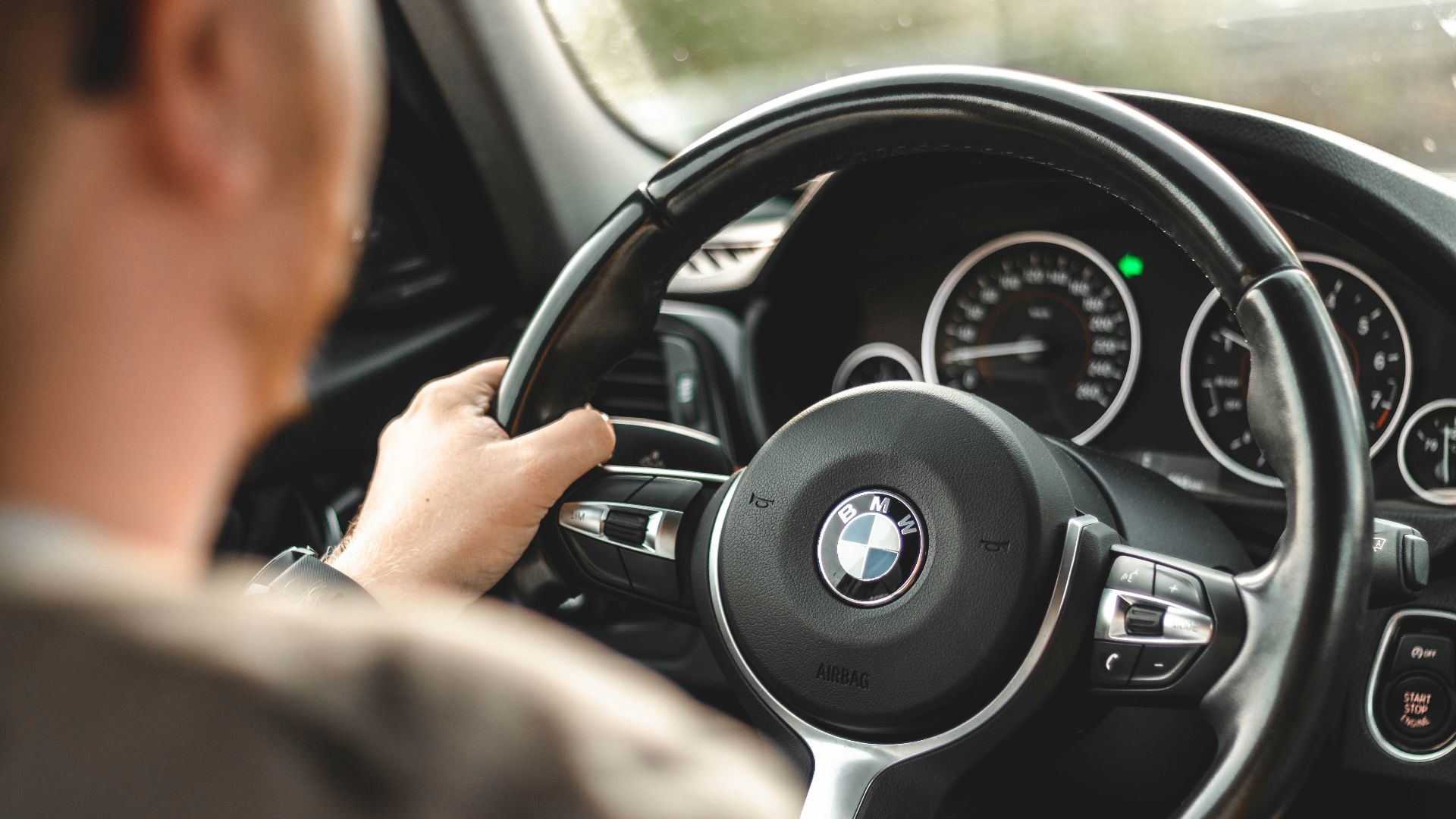 person driving bmw car during daytime