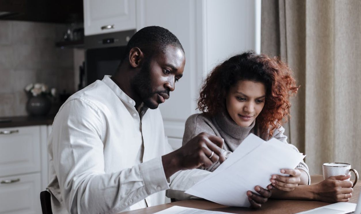 Couple working together on documents at home interior using a laptop