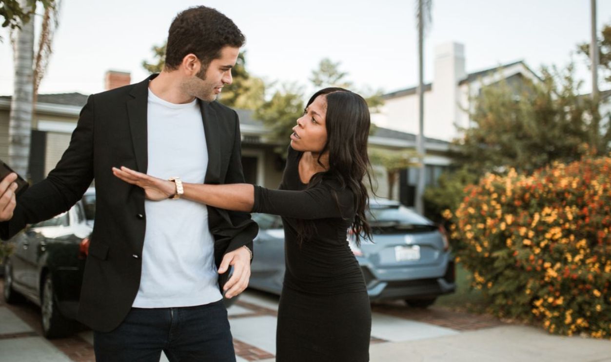 An interracial couple in a heated argument in a suburban neighborhood street