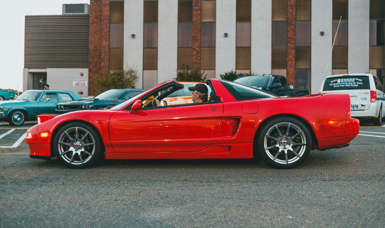 A sleek red convertible car parked outdoors, showcasing modern design and urban lifestyle