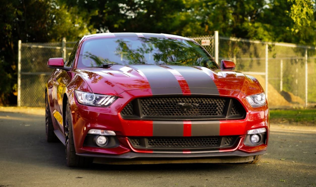 Eye-catching red sports car with racing stripes parked outdoors in Montreal, QC, Canada.