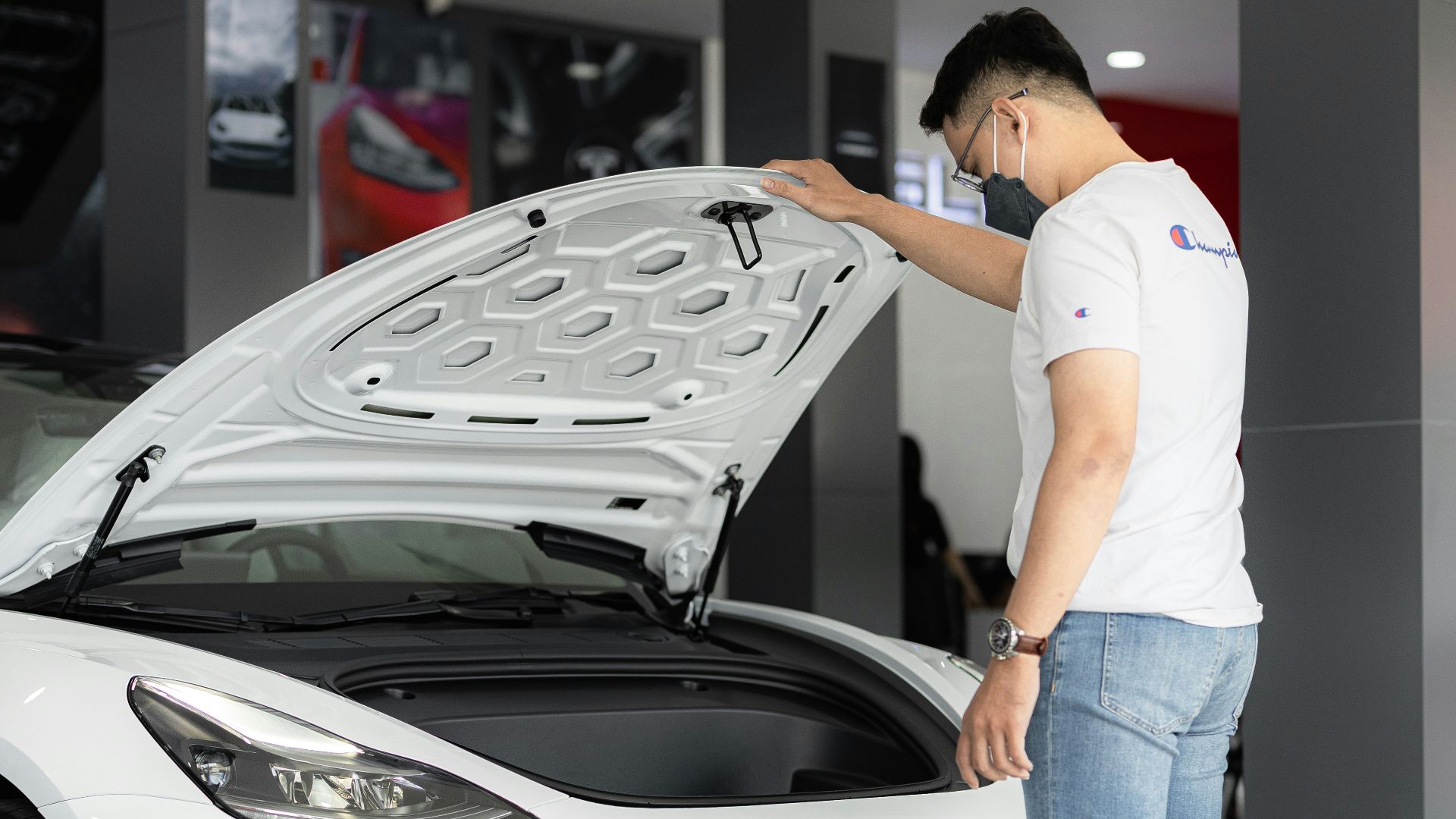 a man looking under the hood of a car