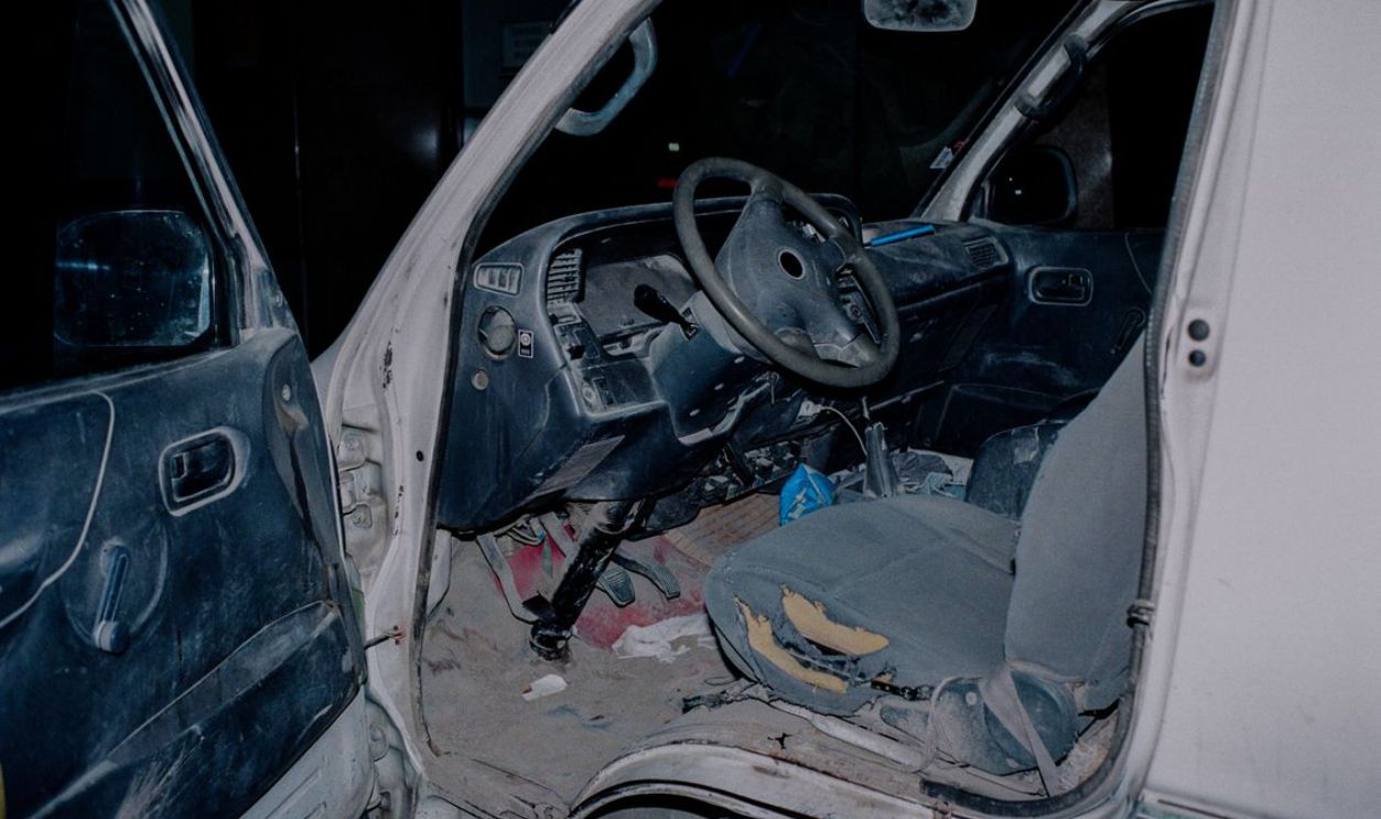 Explore the interior of an old and dirty truck showcasing a worn steering wheel and seat.