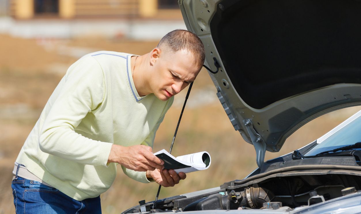 man  broken down car reading   user manual
