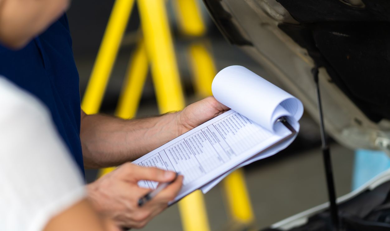 Mechanic man and woman customer check the car condition before delivery. automobile repair maintenance station garage.
