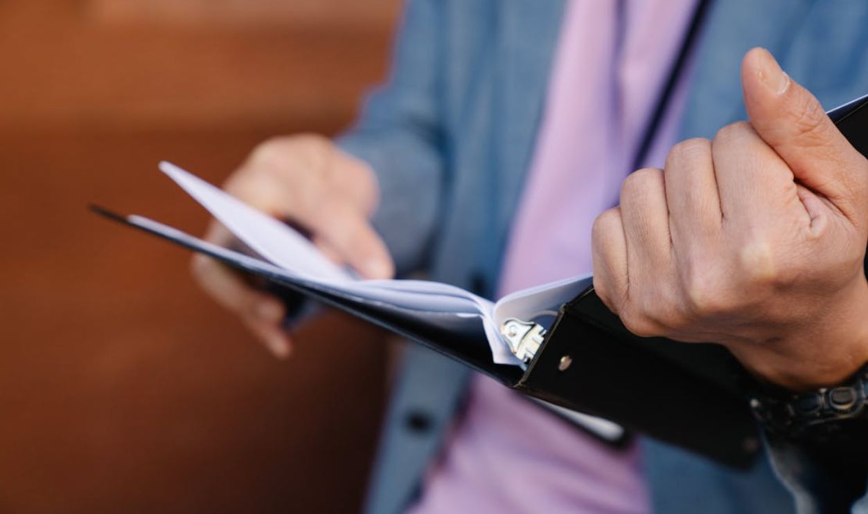 Person flipping through documents in a binder, showcasing organization and focus