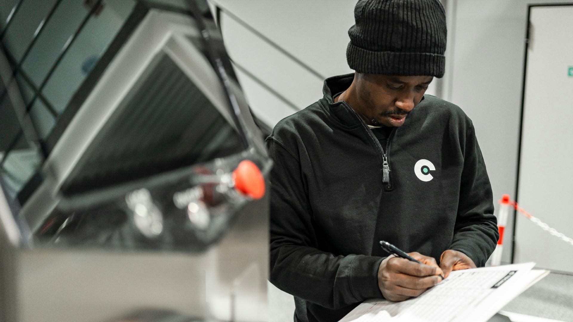 A man is writing by a car.